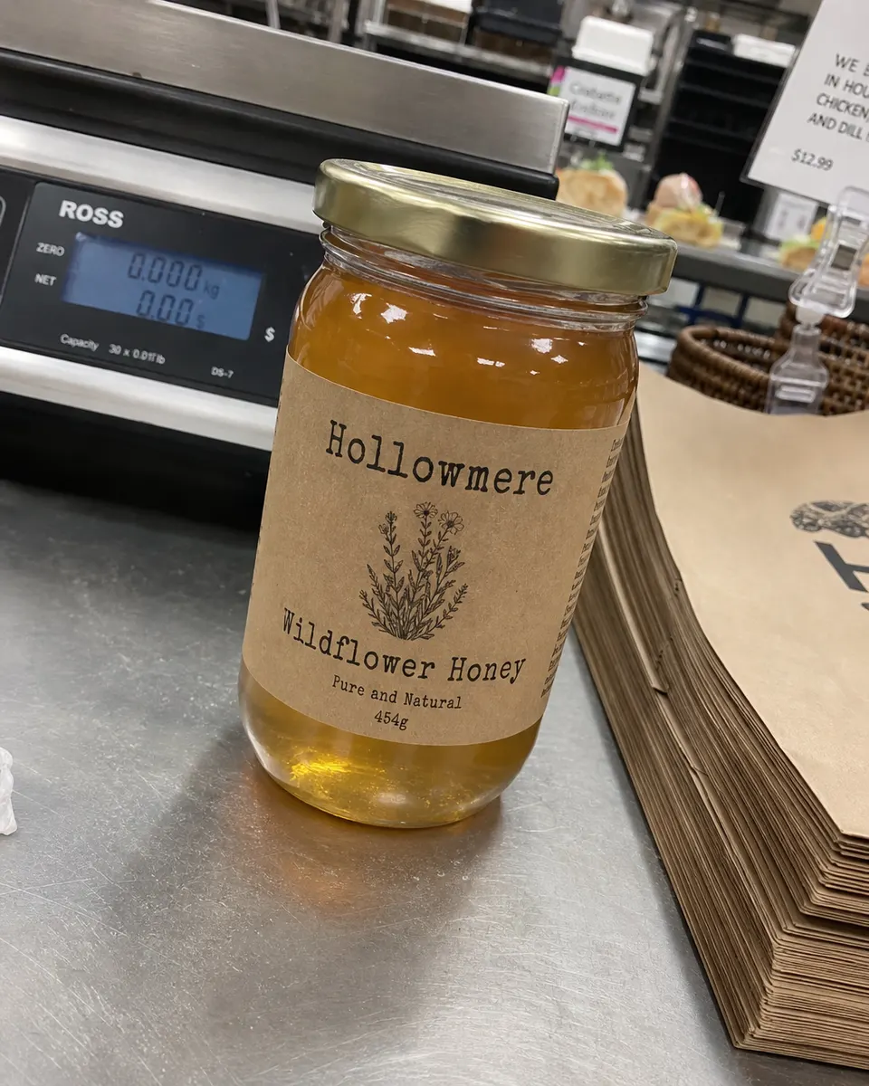 A jar of Hollowmere Wildflower Honey on a busy deli counter